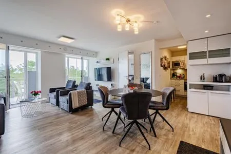 Wohn/Essbereich: Sofa, Sitzbereich, Essbereich, TV, Zugang zum Balkon FeWo Auszeit in PRORA - 9.42