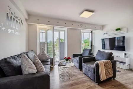 Wohn/Essbereich: Sofa, Sitzbereich, Essbereich, TV, Zugang zum Balkon FeWo Auszeit in PRORA - 9.42