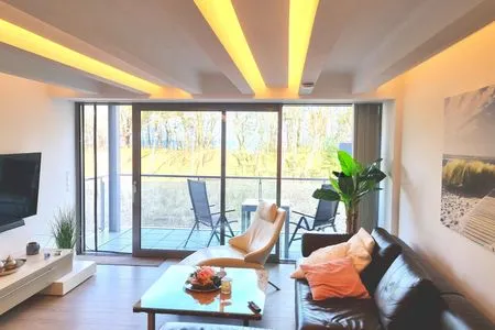 Wohnzimmer: Essbereich, Schlafsofa, Elektro-Kamin, Smart- TV, Zugang zum Balkon FeWo Treibgut in PRORA - 8.12