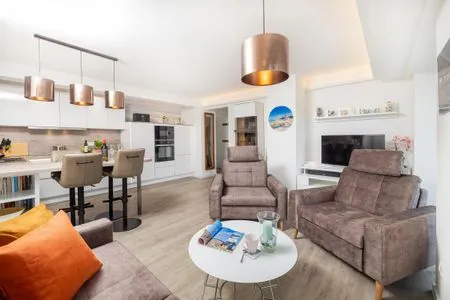 Wohn/Essbereich: Sofa, Essbereich, TV, Zugang zum Balkon FeWo Dünenblick in PRORA - 5.34