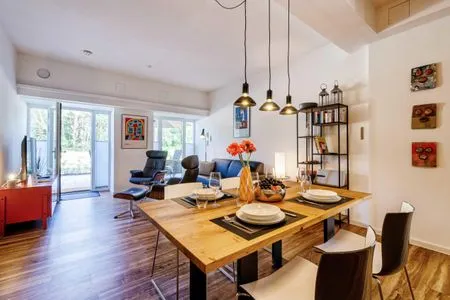 Offener Wohnbereich mit Zugang zur Terrasse, integrierter Küche, Esstisch, ausziehbarer Couch, Relaxsesseln, Smart-TV FeWo Dünenterrasse in PRORA - 9.04