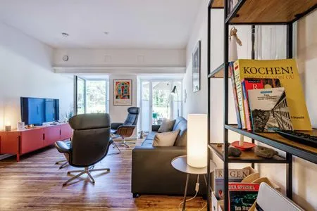 Offener Wohnbereich mit Zugang zur Terrasse, integrierter Küche, Esstisch, ausziehbarer Couch, Relaxsesseln, Smart-TV FeWo Dünenterrasse in PRORA - 9.04