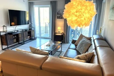 Wohn/Essbereich: Sofa, TV, Zugang zum Balkon FeWo Strandloft in PRORA - 7.12