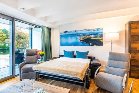 Wohn/Essbereich: Schlafsofa (140x190), Sitzbereich, Essbereich, TV, Zugang zum Balkon FeWo Loft Sturmmöwe in PRORA - 4.12