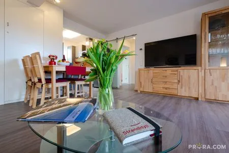 Wohn/Essbereich: Couch und Sessel, TV, Zugang zum Balkon FeWo Strandidyll in PRORA - 9.31