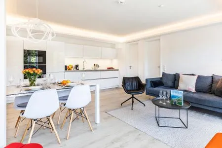 Wohn/Essbereich: Sofa, Sessel, TV, Zugang zum Balkon FeWo MariSol in PRORA Strandnah mit Meerblick & Sauna - 5.22