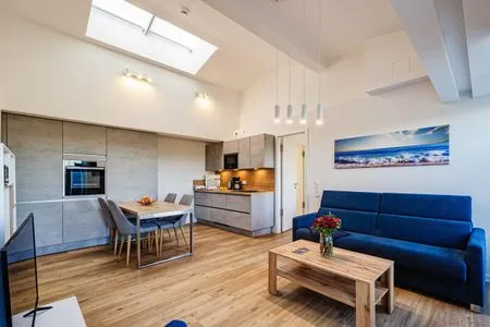 Wohn/Essbereich: Couch und Sessel, TV, Zugang zum Balkon mit Tisch und Stühlen FeWo Meerestraum in PRORA - 5.53