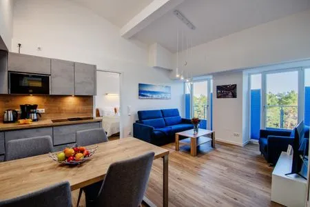 Wohn/Essbereich: Couch und Sessel, TV, Zugang zum Balkon mit Tisch und Stühlen FeWo Meerestraum in PRORA - 5.53