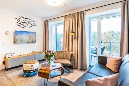 Wohn-/Essraum: Sofa, TV, Zugang zum Balkon FeWo Meerzeit in PRORA - 2.42