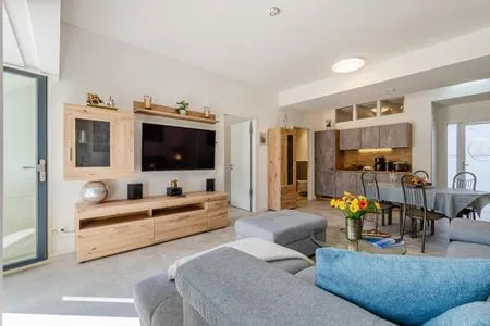 Wohnzimmer: Schlafsofa und Sessel, TV, Essbereich, Zugang zur Terrasse FeWo Proras Strandhaus in PRORA - 9.03