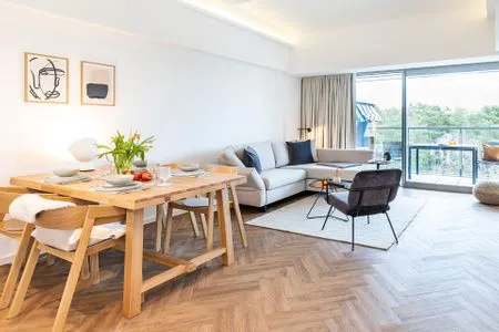 Wohn/Essbereich: Schlafsofa, Smart-TV, Zugang zum Balkon mit Strandkorb, Tisch und Stühlen FeWo Sanddorn in PRORA - 3.53