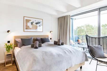 Schlafzimmer 1: Doppelbett (180x200), Kleiderschrank, Smart-TV, Zugang zum Balkon mit 2 Sonnenliegen FeWo Sanddorn in PRORA - 3.53