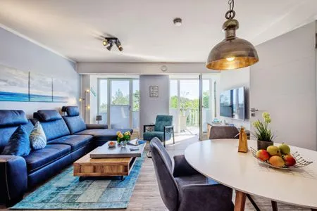 Wohnzimmer: Sofa, TV, Essbereich, Zugang zum Balkon FeWo Strandglück in PRORA - 9.44