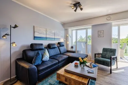 Wohnzimmer: Sofa, TV, Essbereich, Zugang zum Balkon FeWo Strandglück in PRORA - 9.44