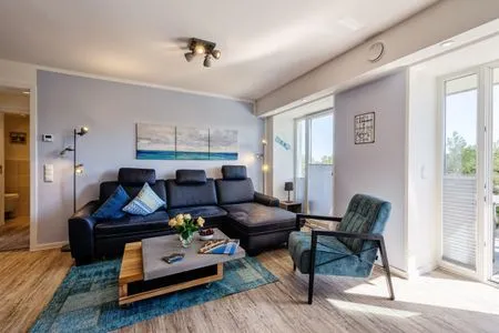 Wohnzimmer: Sofa, TV, Essbereich, Zugang zum Balkon FeWo Strandglück in PRORA - 9.44