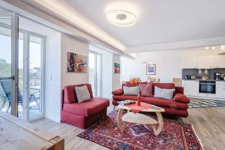 Wohnzimmer: Schlafsofa und Sessel, TV, Essbereich, Zugang zum Balkon FeWo Seemelodie in PRORA - 9.43