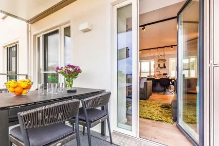 Wohn-/Essbereich: Couchgruppe mit Tisch, Smart-TV, Essbereich, Zugang zum Balkon mit Tisch und Stühlen (Seeseite), Sonne FeWo Hideaway in PRORA - 2.45