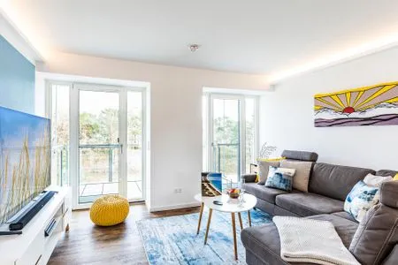 Wohnzimmer: Schlafsofa, TV, Zugang zum Balkon FeWo Baltic Sunrise in PRORA - 3.33