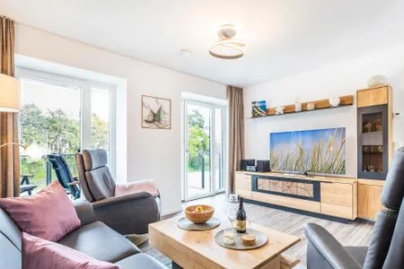 Wohnzimmer: Sofa, 2 Sessel, TV, Zugang zum Balkon FeWo Küstenliebe in PRORA - 2.21