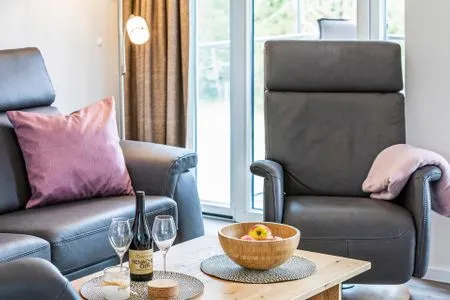 Wohnzimmer: Sofa, 2 Sessel, TV, Zugang zum Balkon FeWo Küstenliebe in PRORA - 2.21