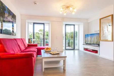 Wohnzimmer: Couch, TV, Essbereich, Zugang zum Balkon FeWo Seeigel in PRORA - 6.34