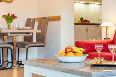 Wohnzimmer: Couch, TV, Essbereich, Zugang zum Balkon FeWo Seeigel in PRORA - 6.34