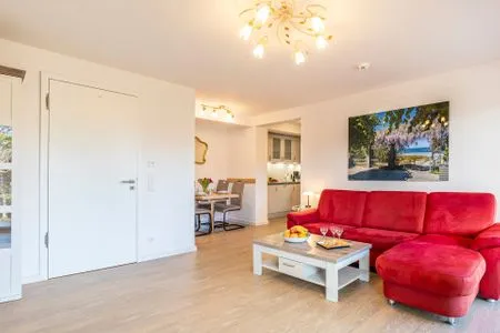 Wohnzimmer: Couch, TV, Essbereich, Zugang zum Balkon FeWo Seeigel in PRORA - 6.34