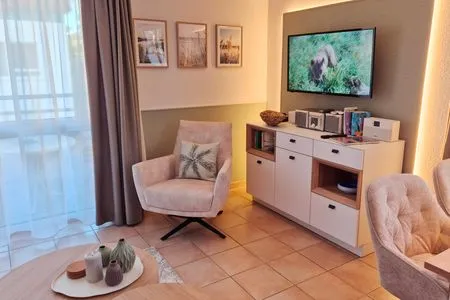 Wohnbereich mit Sessel und TV Residenz am Strand Wohnung 4-61