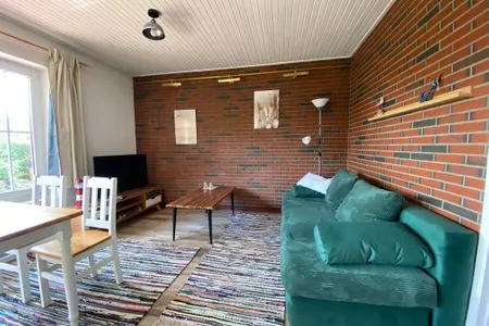 Gemütliches Wohnzimmer mit Sofa und Fernseher Fewo Seeschwalbe A