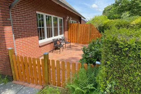 Terrasse mit zwei Stühlen und Blick auf den Garten. Fewo Seeschwalbe A