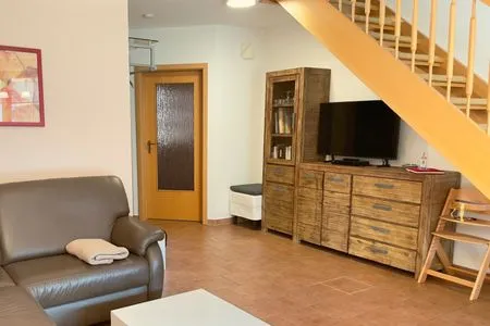 Wohnbereich mit Treppe ins Obergeschoss Ferienpark Freesenbruch Reihenhaus 8b - Muschel