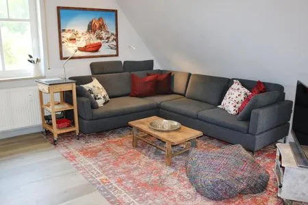 Wohnbereich mit Couch und TV Zum Leuchtturm Wohnung 9