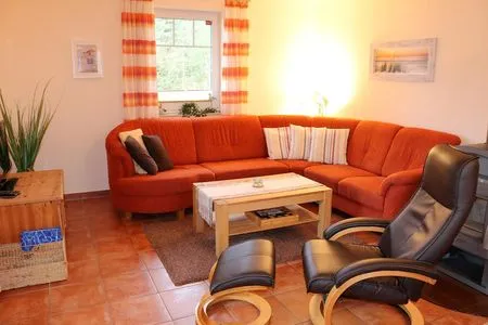 große Couch und Relaxsessel am Kamin Küstenwind
