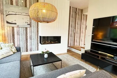 Gas-Kamin und großer Flatscreen-TV im Wohnzimmer Achternhus Kalle