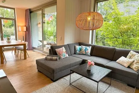 offen gestalteter Wohnbereich mit großen Fensterfronten Achternhus Kalle