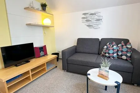 Wohnzimmer mit Couch (mit Schlaffunktion) und Sat-TV Katharinas Ferienhaus Wohnung 4