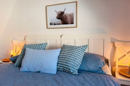 Schlafzimmer mit zwei zusammengeschobenen Einzelbetten, Kleiderschrank und Meerblick Nordkiek No. 8