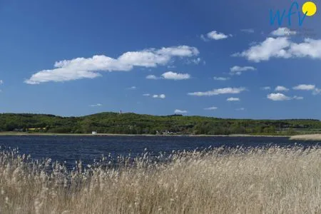 Einen Steinwurf von der Ferienwohnung entfernt tut sich der Blick über den Neuensiener See zum Jagdschloss Granitz auf. Ferienappartements Am Neuensiener See Ferienwohnung 7