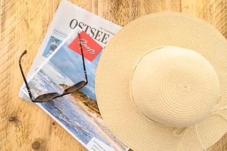Sonnenbrille mit Hut und Zeitungen Residenz am Strand Deichpoofe -  Wohnung 1-06