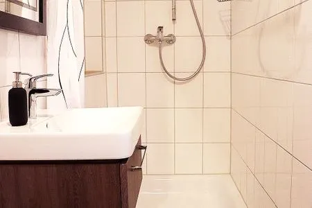 Waschbecken mit Spiegel und Dusche Strandnahe Souterrain-Ferienunterkunft - Mit gratis Bettwäsche-Paket