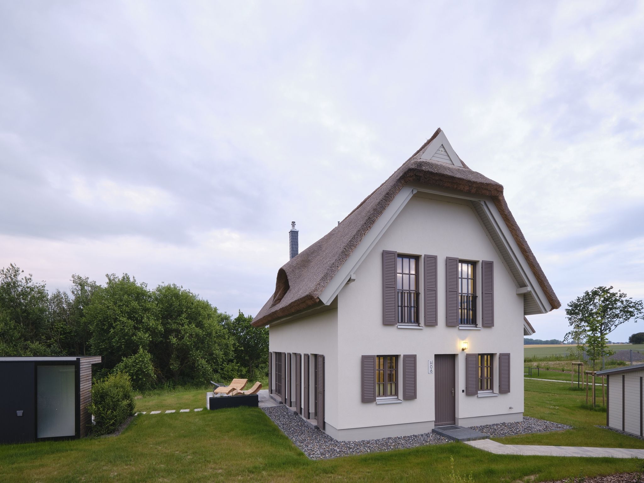 LuxusPlus Reetdachvilla mit 4 Schlafzimmern, Außensauna, Loungebereich und Kamin (H06) - Hauptansicht