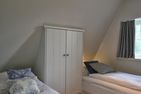  LandLust Borgsum - Das dritte Schlafzimmer verfügt über einen maßgefertigten Einbauschrank.