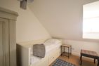  Reethus Dörpsend Haus 2 Midlum - Dieses etwas kleinere Schlafzimmer verfügt über ein Einzelbett, welches sich auch zu einem Doppelbett ausziehen lässt.