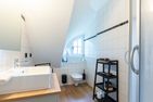  Boddenblick 1 Born auf dem Darß - Helles Bad mit Waschbecken, Toilette, Dusche, Regal und kleinem Fenster.