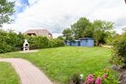  Boddenblick 1 Born auf dem Darß - Großer Garten mit Rasen, Grillplatz, blauem Gartenhaus und umlaufender Hecke.
