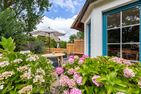  Boddenblick 1 Born auf dem Darß - Terrasse mit Holztisch, Sonnenschirm, Stühlen und blühenden Hortensien.