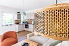  Boddenblick 1 Born auf dem Darß - Wohnzimmer mit Sofa, rotem Sessel, Holztisch und Blick auf offene Küche.