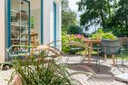  Boddenblick 1 Born auf dem Darß - Terrasse mit Holztisch, Stühlen, Blumenkübeln und Blick in den Garten.