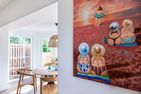  Boddenblick 1 Born auf dem Darß - Buntes Strandgemälde an der Wand, daneben Essbereich mit Holztisch und Stühlen.