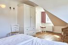  Green Garden Wohnung 2 Wyk auf Föhr - Das erste Schlafzimmer bietet Ihnen einen Rückzugsraum mit Doppelbett und Sitzecke.
